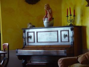 a piano in a living room with a statue on it at Locanda Miranda in Tellaro