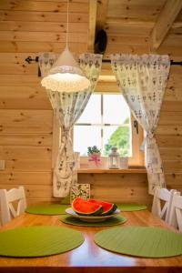 a wooden table with a plate of watermelon on it at Domki KOLONIA LEŚNA z sauną i gorącą balią in Radków