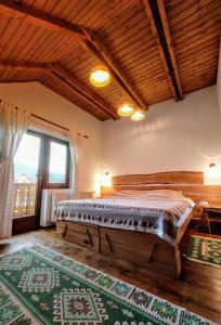 ソバタにあるCasa cu Aburi Sovataのベッドルーム(大型ベッド1台、大きな窓付)