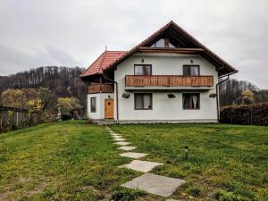 a white house with a pathway in front of it at Casa cu Aburi Sovata in Sovata