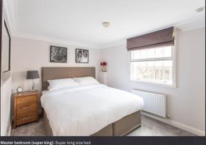 ロンドンにあるHeart of Mayfair - Stunning Apartmentのベッドルーム(大きな白いベッド1台、窓付)