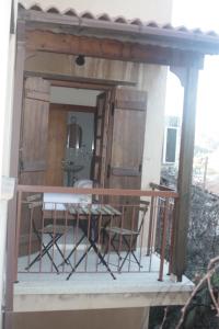 a porch with chairs and a table on a balcony at Maritsa Lodge in Kakopetria