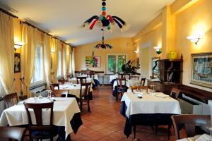 a restaurant with white tables and chairs and a chandelier at Locanda Miranda in Tellaro