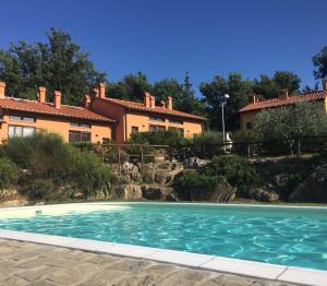 a swimming pool in front of a house at Casa nella campagna di San Gimignano in Gambassi Terme
