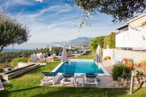 una piscina en un patio con sillas y sombrillas en Villa Vigna, en Camporosso