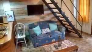 a living room with a blue couch and a tv at Departamentos Lugar de Descanso in El Bolsón