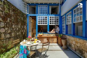 a woman sitting on the balcony of a house at Casa no Centro Histórico com 3 Quartos in Paraty