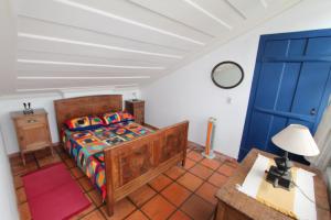 a bedroom with a bed and a blue door at Casa no Centro Histórico com 3 Quartos in Paraty