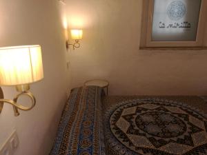 a bedroom with a bed with a lamp and a rug at La Mirilla Suites 2 in Tarifa