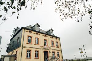 a tall building with a black roof at Landhotel Airport-Inn in Lautzenhausen