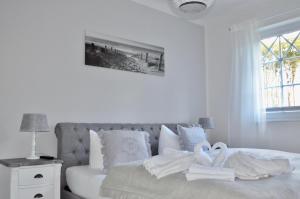 Un dormitorio blanco con una cama con toallas. en Villa Strandblick 10, en Zingst
