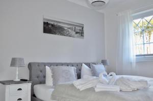a white bedroom with a bed with towels on it at Villa Strandblick 10 in Zingst