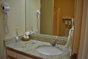 a bathroom with a sink and a mirror at Baymont by Wyndham Wichita East in Wichita