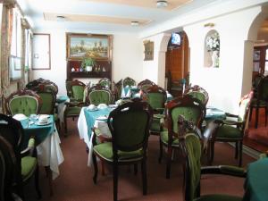 a dining room with tables and green chairs at Havelock Guesthouse in Saint Helier Jersey