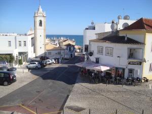 een straat in een stad met een klokkentoren bij Vila Algarvia Boutique & Suites in Albufeira