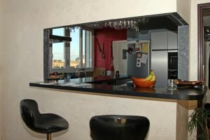 サン・ナゼールにあるSUITE-HOME Appartement d'exceptionのキッチン(黒いカウンタートップ、黒いスツール付)