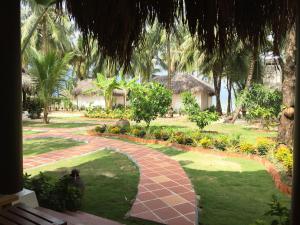 a garden with a brick walkway in front of a resort at Peppercorn Beach Resort in Phú Quốc