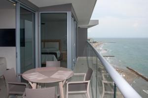 balcone con tavolo, sedie e vista sull'oceano di Apartamentos Morros City Cartagena a Cartagena de Indias