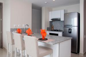 una cucina con bancone, sedie e frigorifero di Apartamentos Morros City Cartagena a Cartagena de Indias
