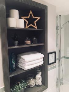 a bathroom shelf with towels and a star on it at No.10 Broadway in Broadway