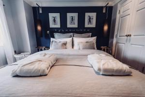 1 dormitorio con 1 cama grande con almohadas blancas en No.10 Broadway, en Broadway