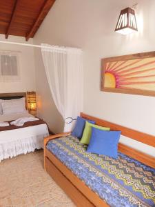 um quarto com uma cama com travesseiros azuis em Pousada Suites do Santinho em Florianópolis