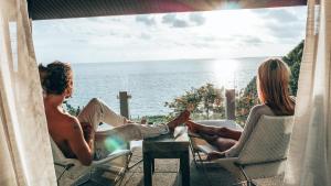 a man and a woman sitting in chairs on the beach at The Houben - Adult Only in Ko Lanta