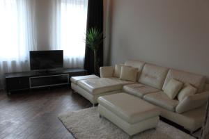 a living room with a couch and a tv at Apartamentai Kauno centre in Kaunas