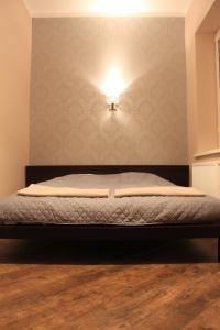a bedroom with a bed with a light on the wall at Apartamentai Kauno centre in Kaunas