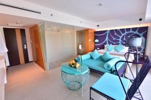 a living room with a blue couch and a bed at Hue Hotels and Resorts Boracay Managed by HII in Boracay