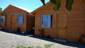 a couple of buildings with windows and a door at Cabañas El Sol de Dichato in Dichato