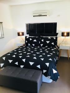ein Schlafzimmer mit einem schwarzen und weißen Bett und zwei Lampen in der Unterkunft Cottage on Cork Steadman Cottage in Winton