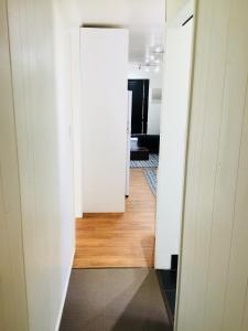 a hallway leading into a room with white walls and wood floors at Cottage on Cork - Muddy Cottage in Winton