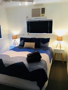 a bedroom with a bed with a bag on it at Cottage on Cork - Muddy Cottage in Winton