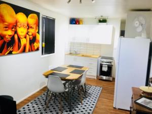 a kitchen with a table and chairs in a room at Cottage on Cork - Muddy Cottage in Winton +13 photos