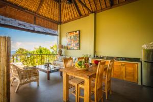 Una cocina y un comedor con mesa y sillas. en Aquamarine Beach Villas, en Amed