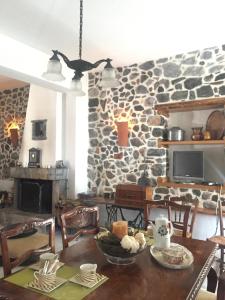 a dining room with a table and a stone wall at Stephania's Stone House in Karyes