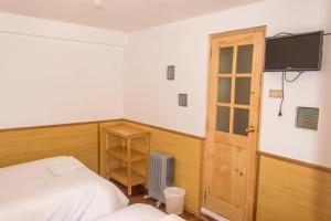 a bedroom with a bed and a tv on the wall at Casa Don Jose B & B in Puno