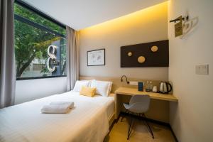 a hotel room with a bed and a desk at Gold3 Boutique Hotel in Kuala Lumpur