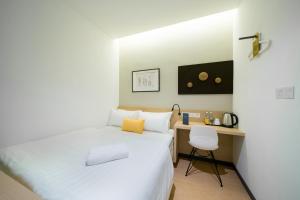 
a hotel room with two beds and a desk at Gold3 Boutique Hotel in Kuala Lumpur
