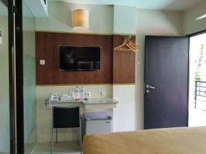 a room with a kitchen with a table and a tv at Sanur Agung Hotel in Sanur