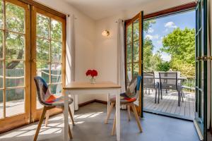 comedor con mesa y sillas y balcón en Rosehaven Cottage en Hobart