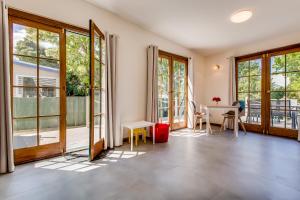 um quarto com janelas e uma mesa e cadeiras em Rosehaven Cottage em Hobart