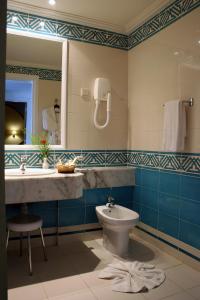 La salle de bains est pourvue d'un lavabo, de toilettes et d'un miroir. dans l'établissement El Mouradi Mahdia, à Mahdia