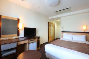 札幌市にあるホテル法華クラブ札幌のベッド1台、薄型テレビが備わるホテルルームです。