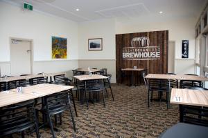 a dining room with tables and chairs and a sign at Great Ocean Road Brewhouse Apollo Bay in Apollo Bay