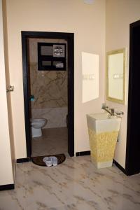 a bathroom with a shower and a toilet and a sink at Opera Suites in Muhayil