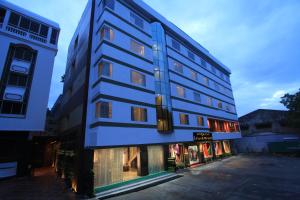 a tall blue building next to a store at Sandesh Pride in Mysore