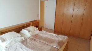 1 dormitorio con 2 camas y armario de madera en Gut Richthofen en Swakopmund