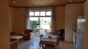 a kitchen and living room with a table and a refrigerator at Gut Richthofen in Swakopmund